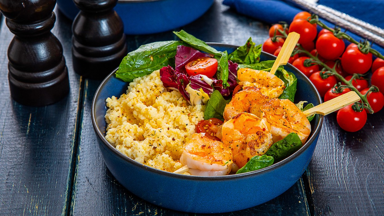 Обжаренные шашлычки из креветок с кускусом в шафрановом соусе и микс-салатом с помидорами черри, приправленным заправкой чимичурри